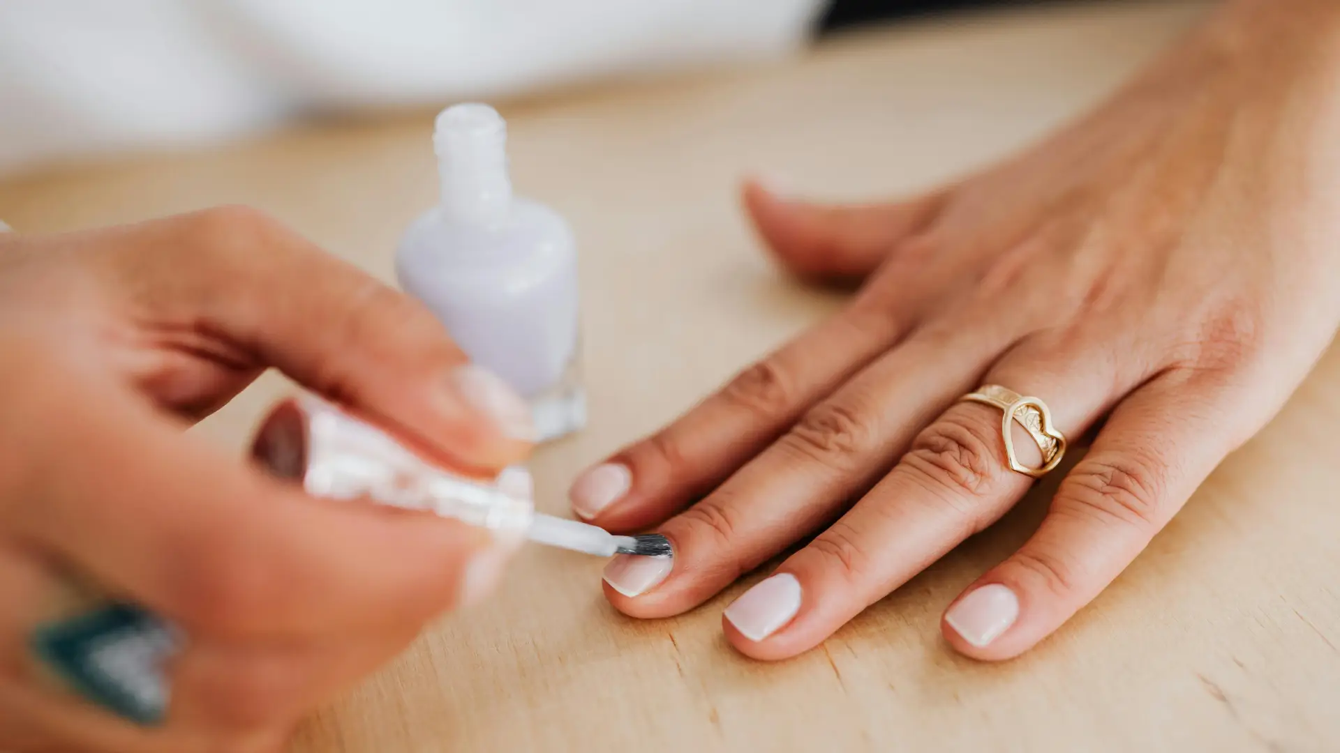 Vrouw haar nagels worden professioneel gelakt bij de nagelstudio.
